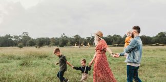 family of five walking in a grass field
