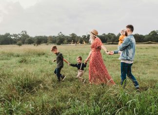 The Joy of Family Traditions family of five walking in a grass field
