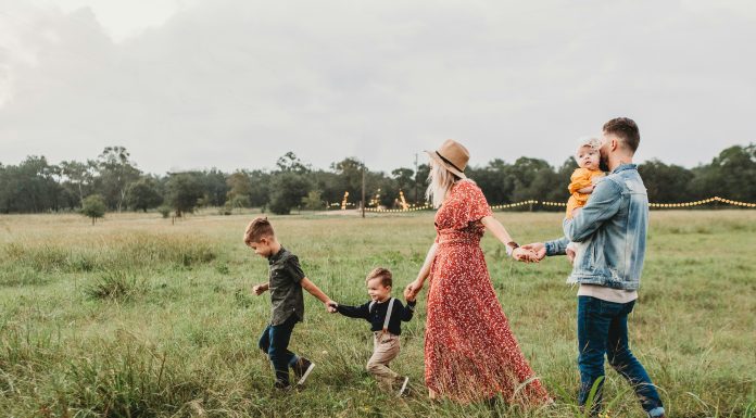 The Joy of Family Traditions family of five walking in a grass field