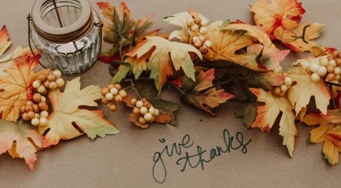 Thanksgiving Recipe Collection: Favorites From Your OMB Team priscilla-du-preez via unsplash candle and leaves on brown paper with words 'give thanks' in marker written on the paper
