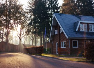 rowan-heuvel via unsplash brick house in the trees with the sun shining through