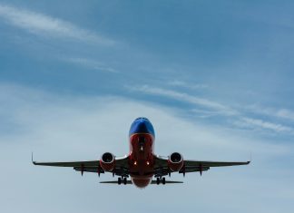 The Trip of a Lifetime gary-lopater via unsplash red and blue airplane headed for the camera with a cloudy sky behind it