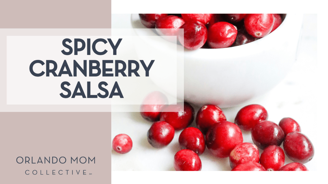 Spicy Cranberry Salsa Melissa Di Rocco via Unsplash cranberries in a white bowl and some spilled out on a white countertop with 'spicy cranberry salsa' on the left.