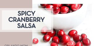 Melissa Di Rocco via Unsplash cranberries in a white bowl and some spilled out on a white countertop with 'spicy cranberry salsa' on the left.