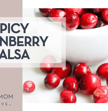Spicy Cranberry Salsa Melissa Di Rocco via Unsplash cranberries in a white bowl and some spilled out on a white countertop with 'spicy cranberry salsa' on the left.