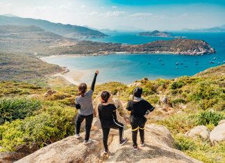Collecting Vacation Memories Tron Le via Unsplash three women on a rock overlooking forrest and the ocean