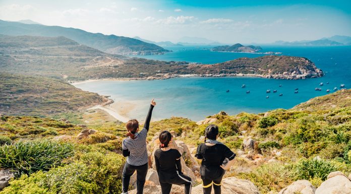 Tron Le via Unsplash three women on a rock overlooking forrest and the ocean