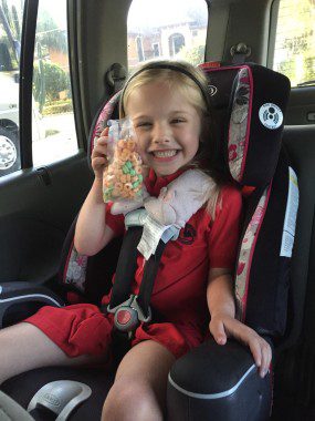 Strapped in and ready to roll with her snack.