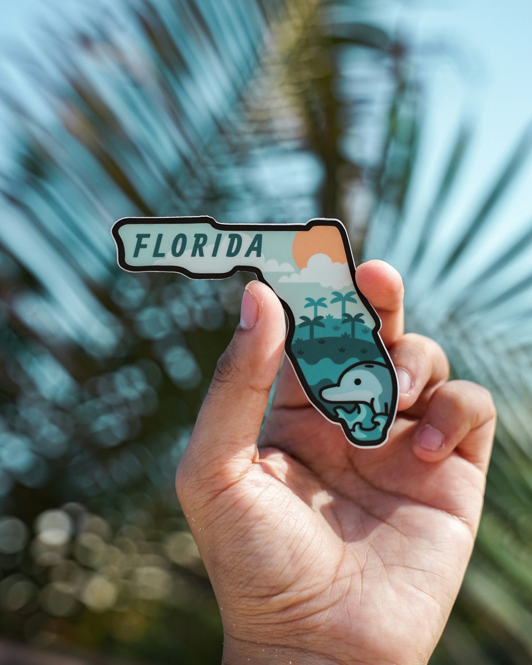 Dr Philips and Windermere done-by-alex via unsplash a hand holding a sticker in the shape of Florida