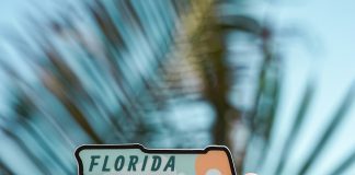 done-by-alex via unsplash a hand holding a sticker in the shape of Florida