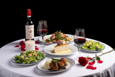 tablescape of wine, main dishes, heart-shaped dessert, roses on the table for valentine's day date guide