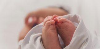 The evening we were transported to AdventHealth for Children’s NICU unit Luma Pimentel via Unsplash newborn baby feet wrapped in white blanket