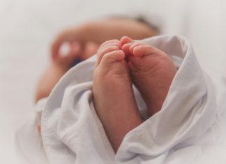 The evening we were transported to AdventHealth for Children’s NICU unit Luma Pimentel via Unsplash newborn baby feet wrapped in white blanket