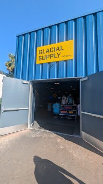 glacial supply sign in yellow on a blue background with open doors below