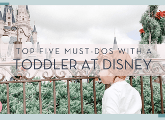 little girl in front of cinderella castle at the fence with 'top five must-dos with a toddler at disney' in font in front of image