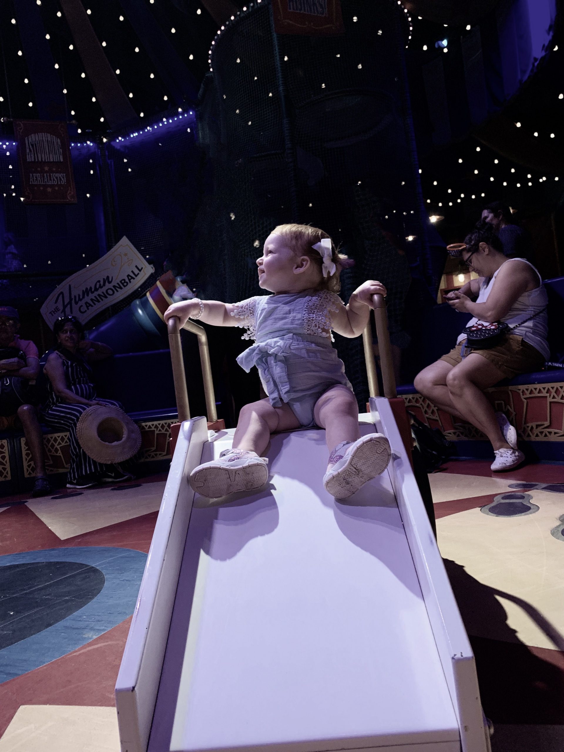 little girl on a slide with a dark background