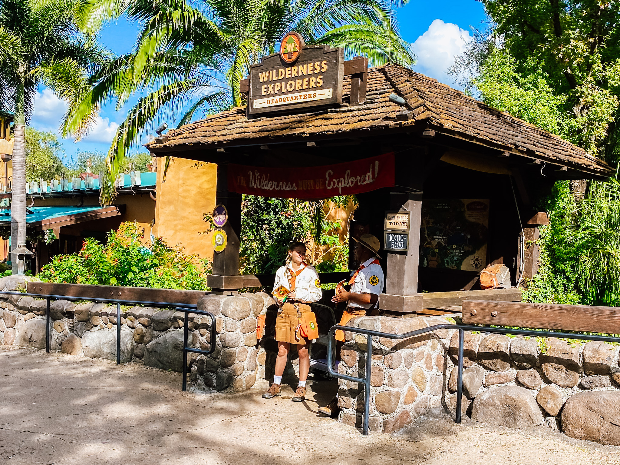 Wilderness Explorers Hut with two cast members standing under it