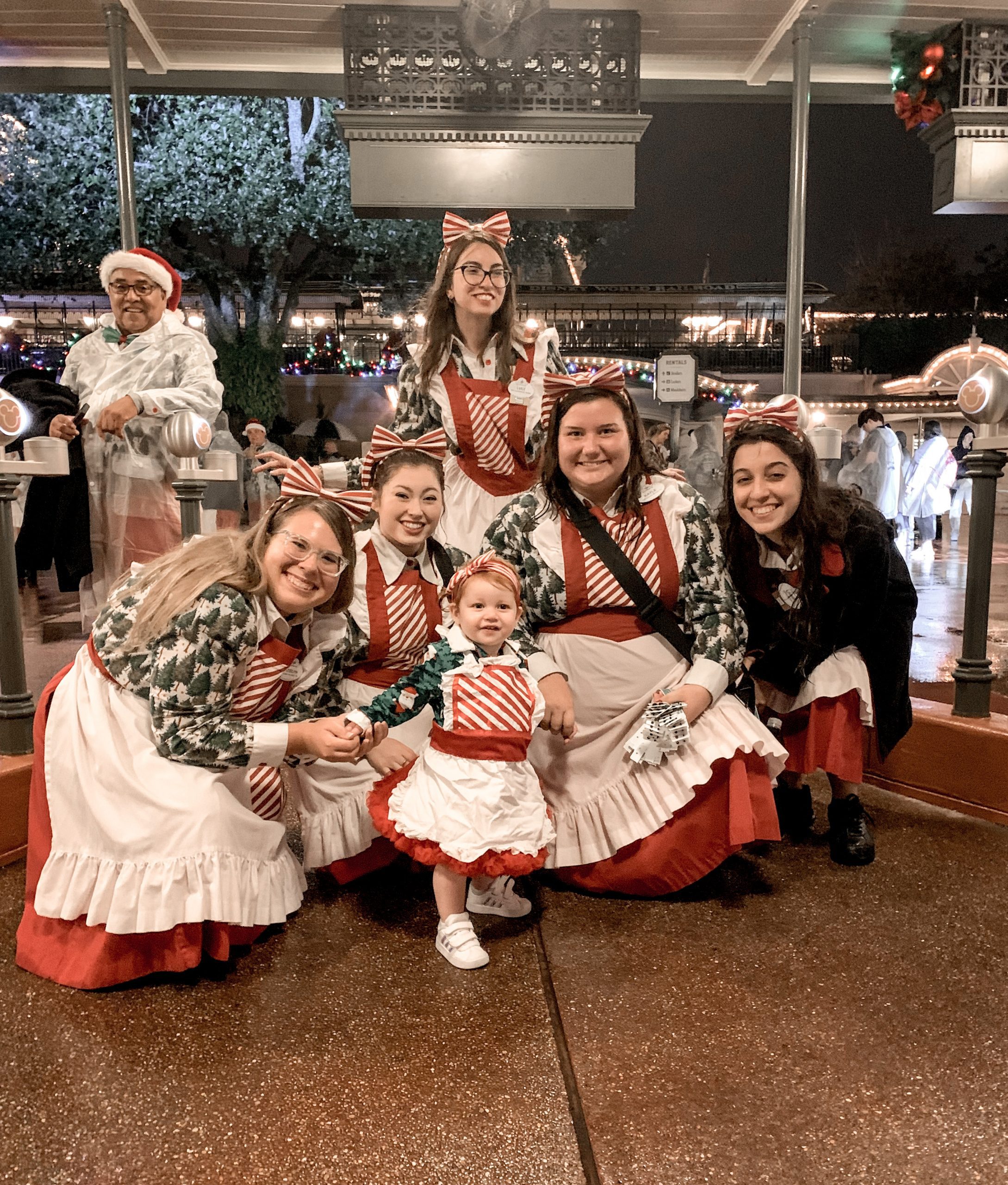 little girl in costume to match 5 female cast members behind her