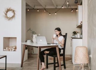 woman drinking coffee staring at her computer, presumably in the early morning. waking up before your kids