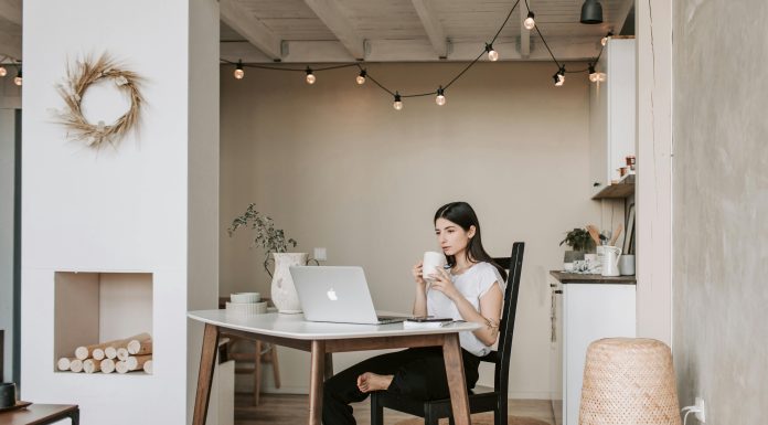 woman drinking coffee staring at her computer, presumably in the early morning. waking up before your kids