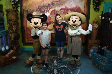 Mom and daughter smiling with Mickey and Minnie Mouse at Disney's Animal Kingdom