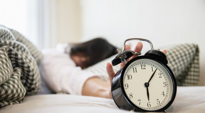 5 Easy Ways to Make Your Mornings Better Sleepy woman reaching holding the alarm clock in the morning with late wake up - every day life at home concept; morning better