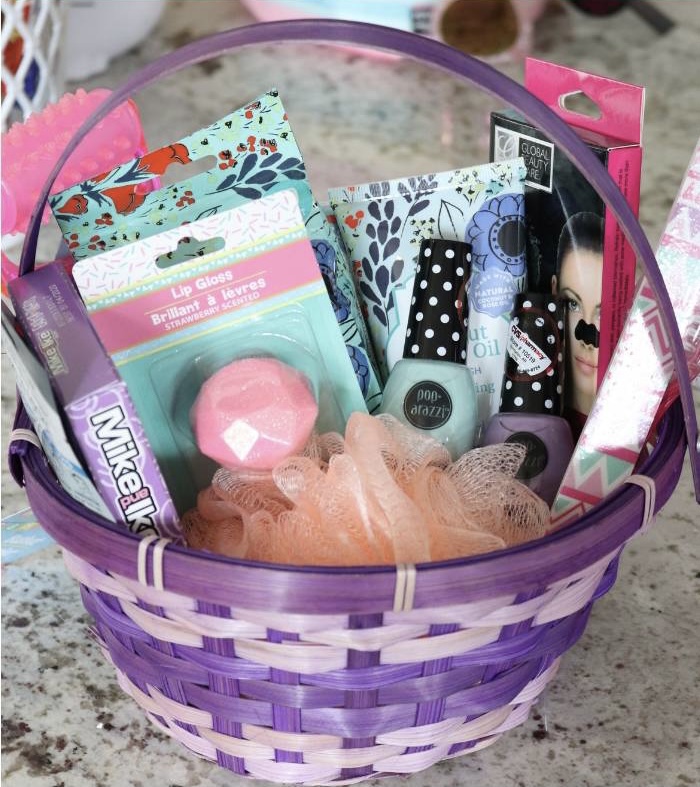 purple Easter Basket with loofa, lip gloss, nail polish and face masks coming out of the top