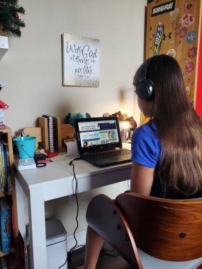 Tween girl doing virtual school on her laptop