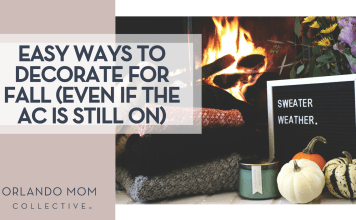 Easy Ways to Decorate for Fall (Even If The AC Is Still On) Rikkia Hughes via Unsplash fire in a fireplace with folded sweaters, a candle, little pumpkins and a sign that says 'sweater weather' in front of the fire with 'Easy Ways to Decorate for Fall (Even If The AC Is Still On)' on the left