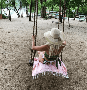 woman sitting on a swing on the turkish towel