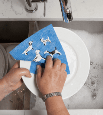 man washing dishes with dog dish cloth