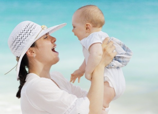 mom holding baby at the beach