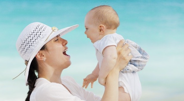 mom holding baby at the beach