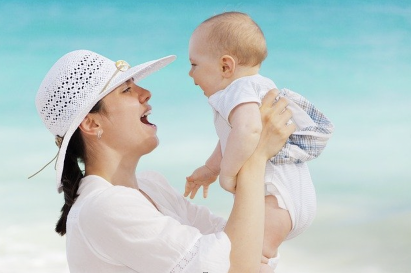 mom holding baby at the beach