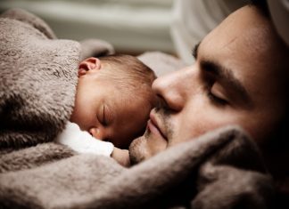 father laying down with newborn on chest