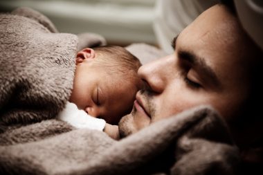 father laying down with newborn on chest