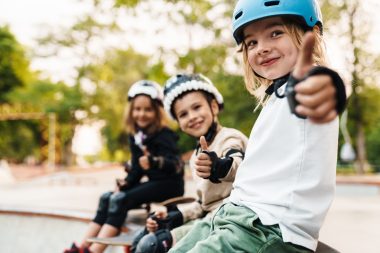 Happy cheerful kids with skateboards at the ramp