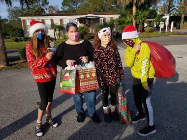 A group of tween girls sharing Christmas toys and gifts for Nathaniel's Hope Caroling Caravan in 2020