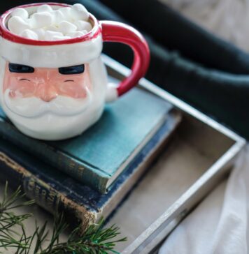 Drew Coffman via Unsplash Santa mug with marshmallows coming out the top on a stack of books
