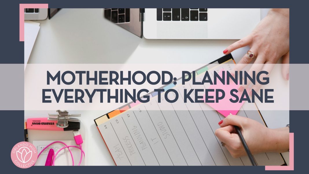 woman writing in a planner with a pen on a planner and post it note with an open computer beside her hand with words 'Motherhood: Planning Everything to Keep Sane' overtop