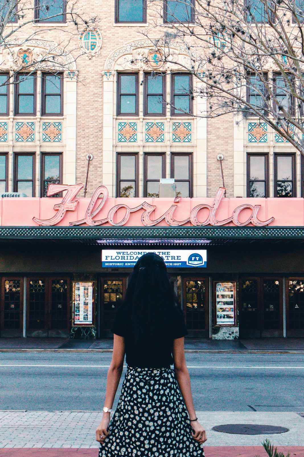 Woman standing in front of a Florida thinking of the top 5 family vacation destinations near central florida