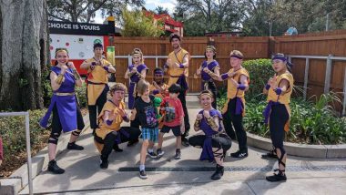 two boys with 8 adults in orange and purple ninja costumes