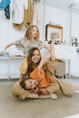 a women with cute girls playing over the carpet; breaking cycles