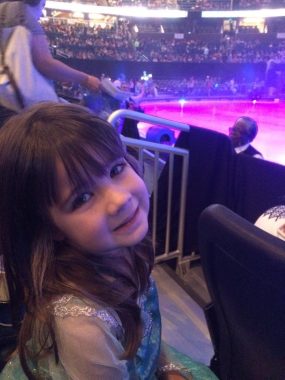 child at Frozen on Ice smiling at camera. 