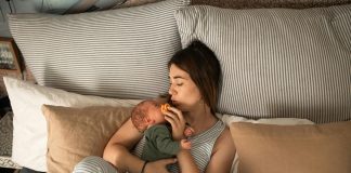 Beauty and Wellness Tips for Postpartum Recovery mom cuddling newborn baby in bed. Beauty and Wellness Tips for Postpartum Recovery