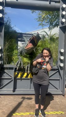 Woman standing in front of fake dinosaur from Jurassic park: Guide to universal studios