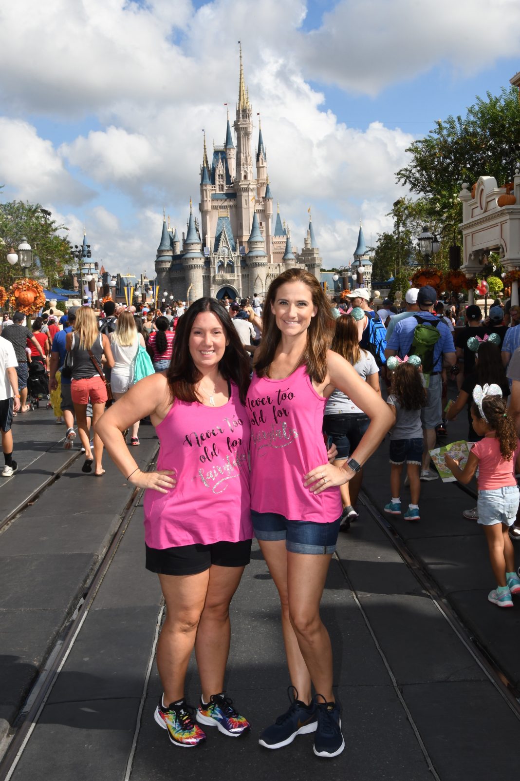 two women smiling at camera in front of Cinderella's castle in Disney World Orlando. On a girls trip