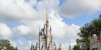 two women smiling at camera in front of Cinderella's castle in Disney World Orlando. On a girls trip