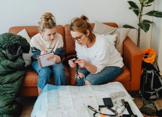 mom and daughter looking at a map and writing notes down for a pre travel checklist