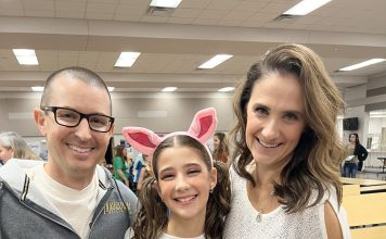 a mom, dad, and daughter staring at the camera smiling.